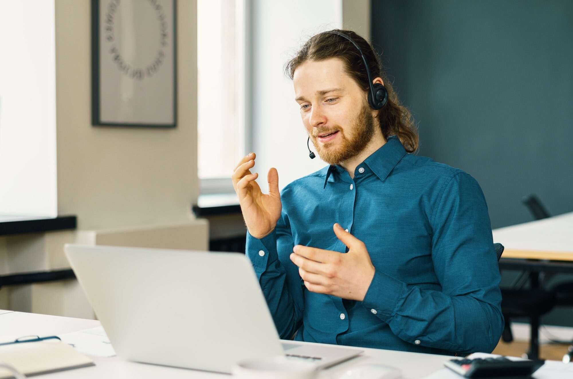 Young man professional call center operator in headset talking with client